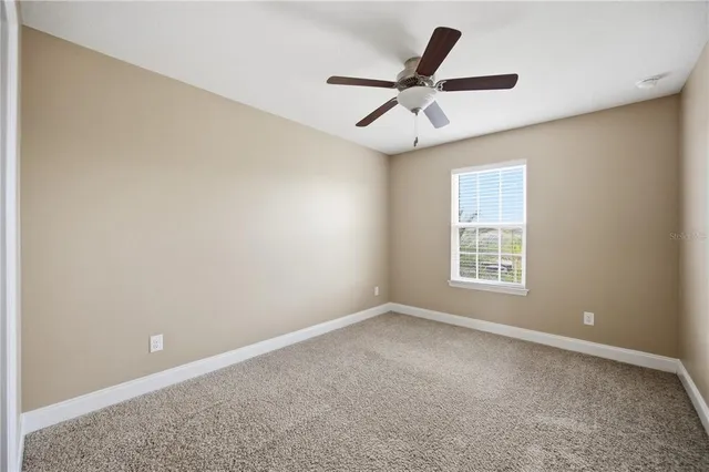 an empty room with chandelier fan