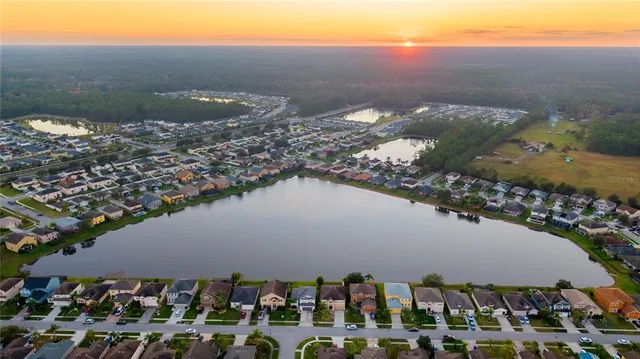 an aerial view of a house with a yard and lake view