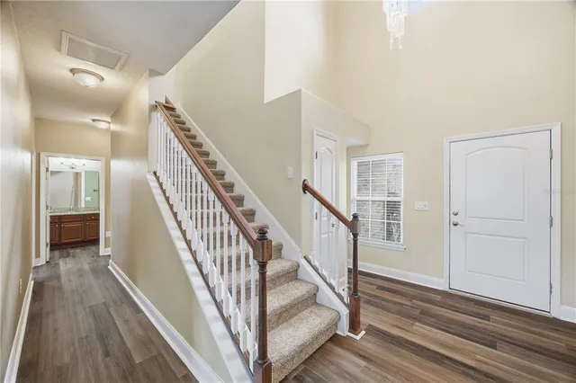 a view of a hallway with wooden floor and staircase