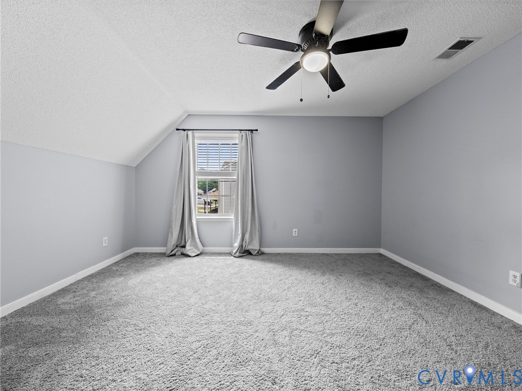 6712 Hedges Road Richmond, VA 23224 - Photo 16 of 34 Spacious room featuring sloped ceilings, light gra