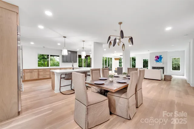 a dining room with furniture a chandelier and wooden floor