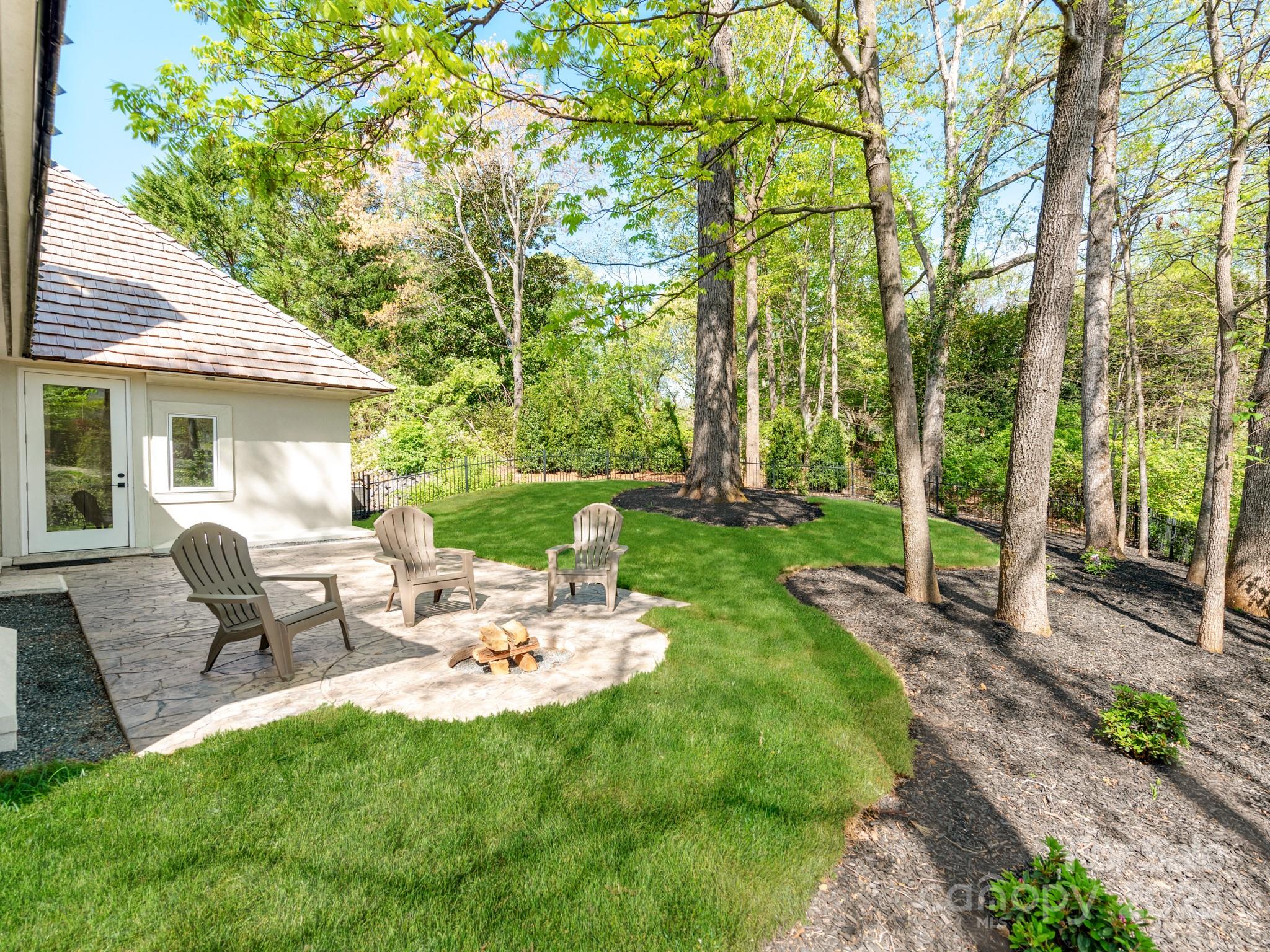 1417 South Wendover Road Charlotte, NC 28211 - Photo 42 of 44 a view of a backyard with table and chairs potted plants and large tree