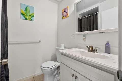 a bathroom with a sink vanity mirror and toilet