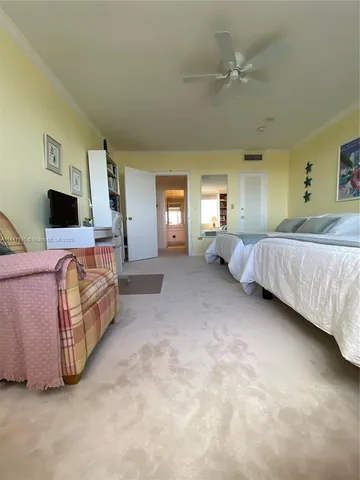 a spacious bedroom with a bed couch and window