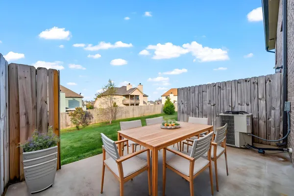 a view of a chairs and table in the back yard of the house