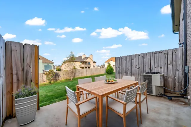 a view of a chairs and table in the back yard of the house