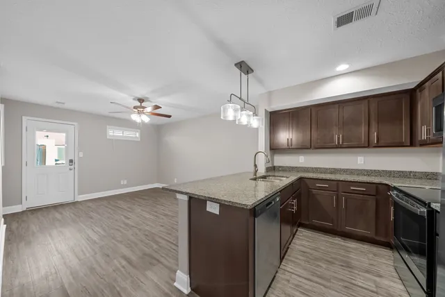 a kitchen with stainless steel appliances granite countertop a sink refrigerator and microwave