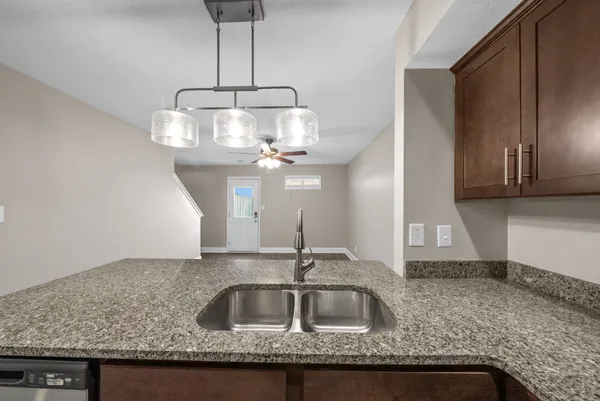 a kitchen with a sink a refrigerator and chandelier