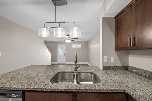 a kitchen with a sink a refrigerator and chandelier