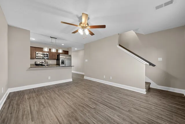 a view of a room with wooden floor and white walls