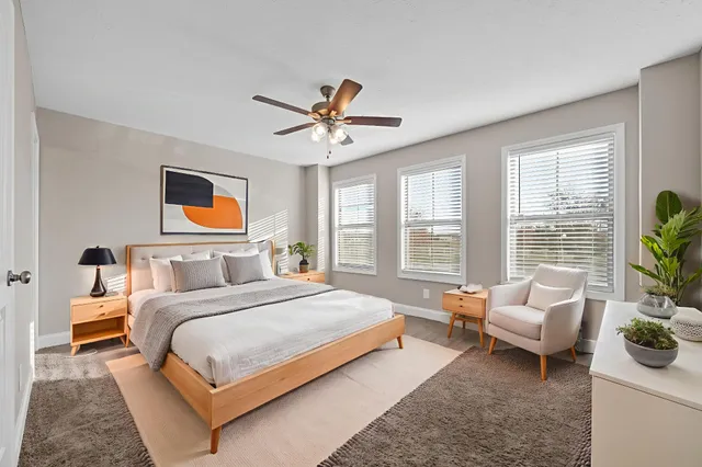 a bedroom with a bed couch and a large window