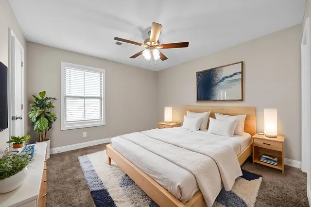a bedroom with a bed a window and potted plant