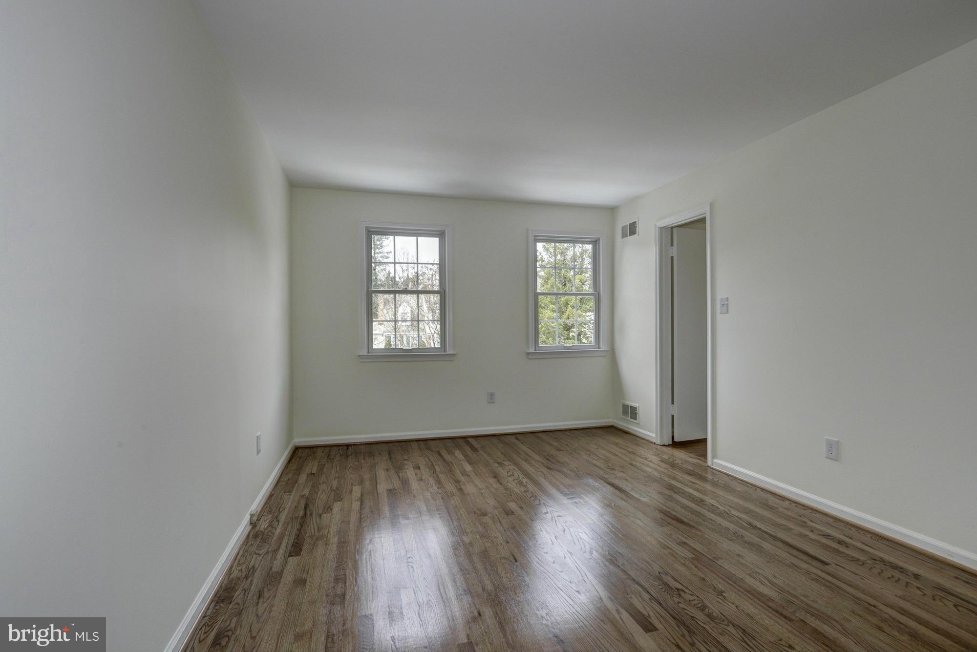 14117 Sturtevant Road Silver Spring, MD 20905 - Photo 13 of 30 an empty room with wooden floor and windows