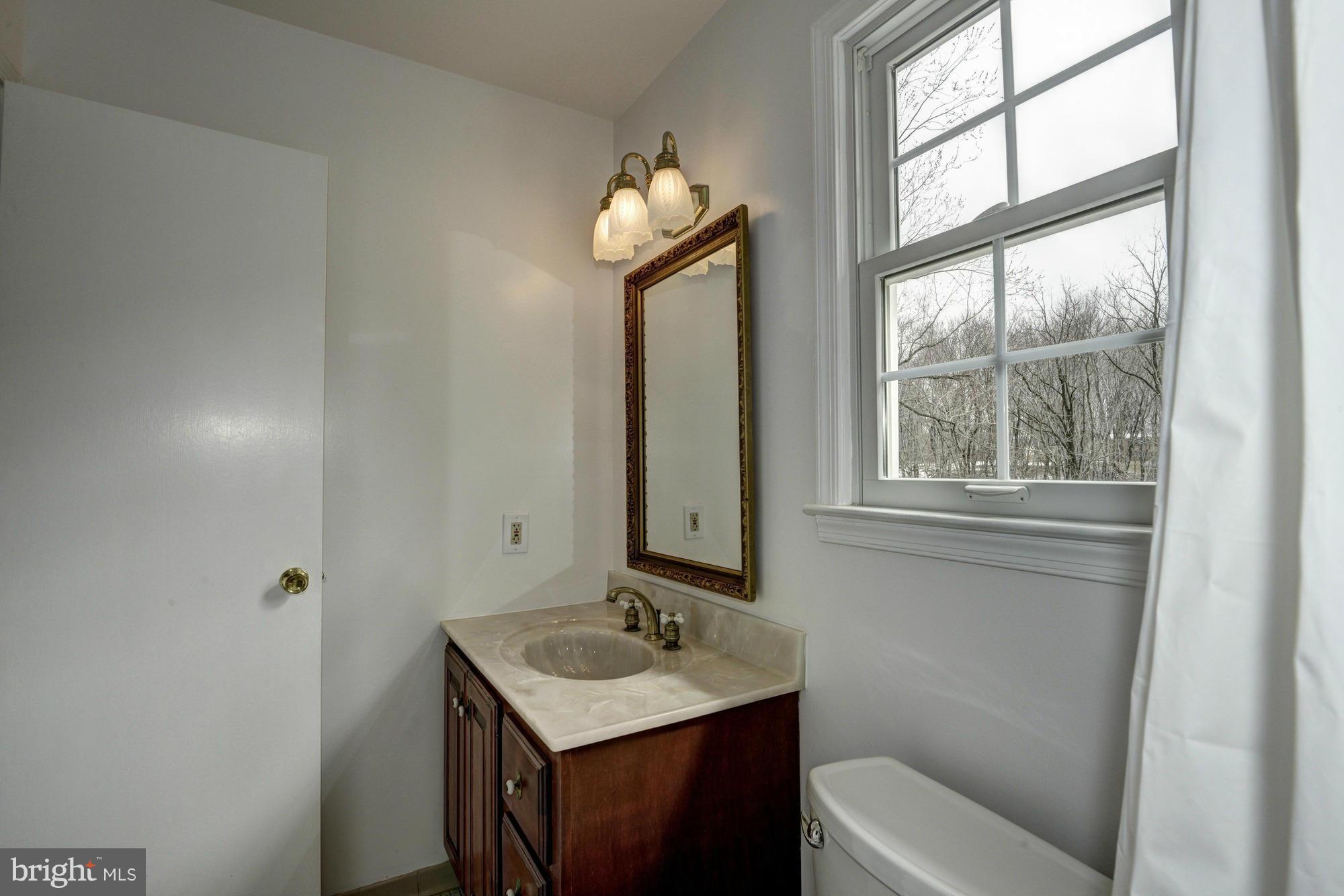 14117 Sturtevant Road Silver Spring, MD 20905 - Photo 14 of 30 a bathroom with a sink a toilet and a mirror