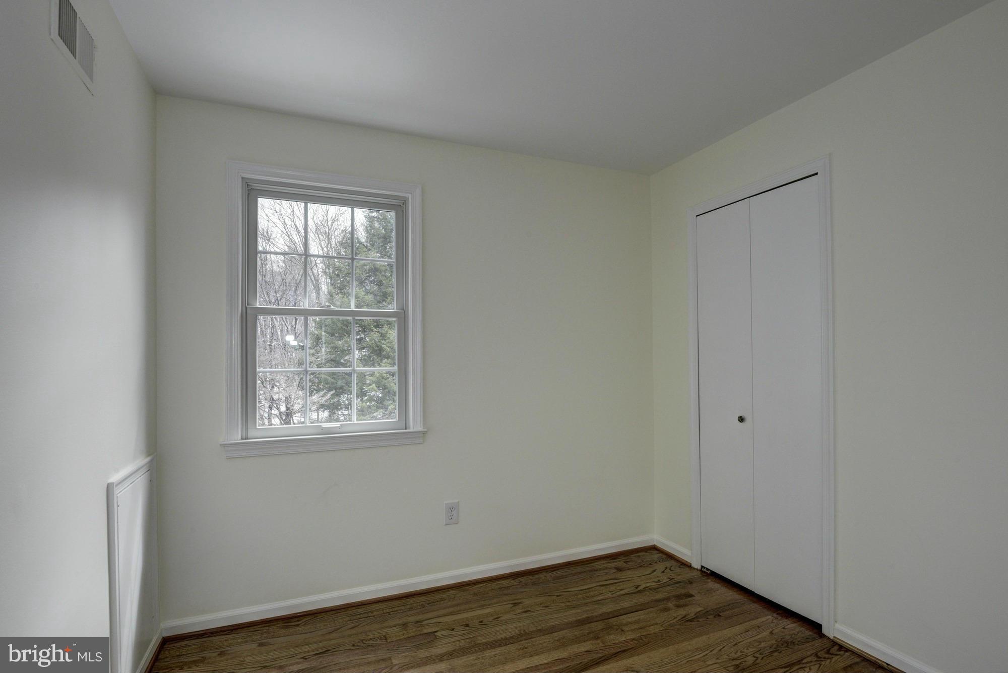 14117 Sturtevant Road Silver Spring, MD 20905 - Photo 16 of 30 a view of an empty room with wooden floor and a window