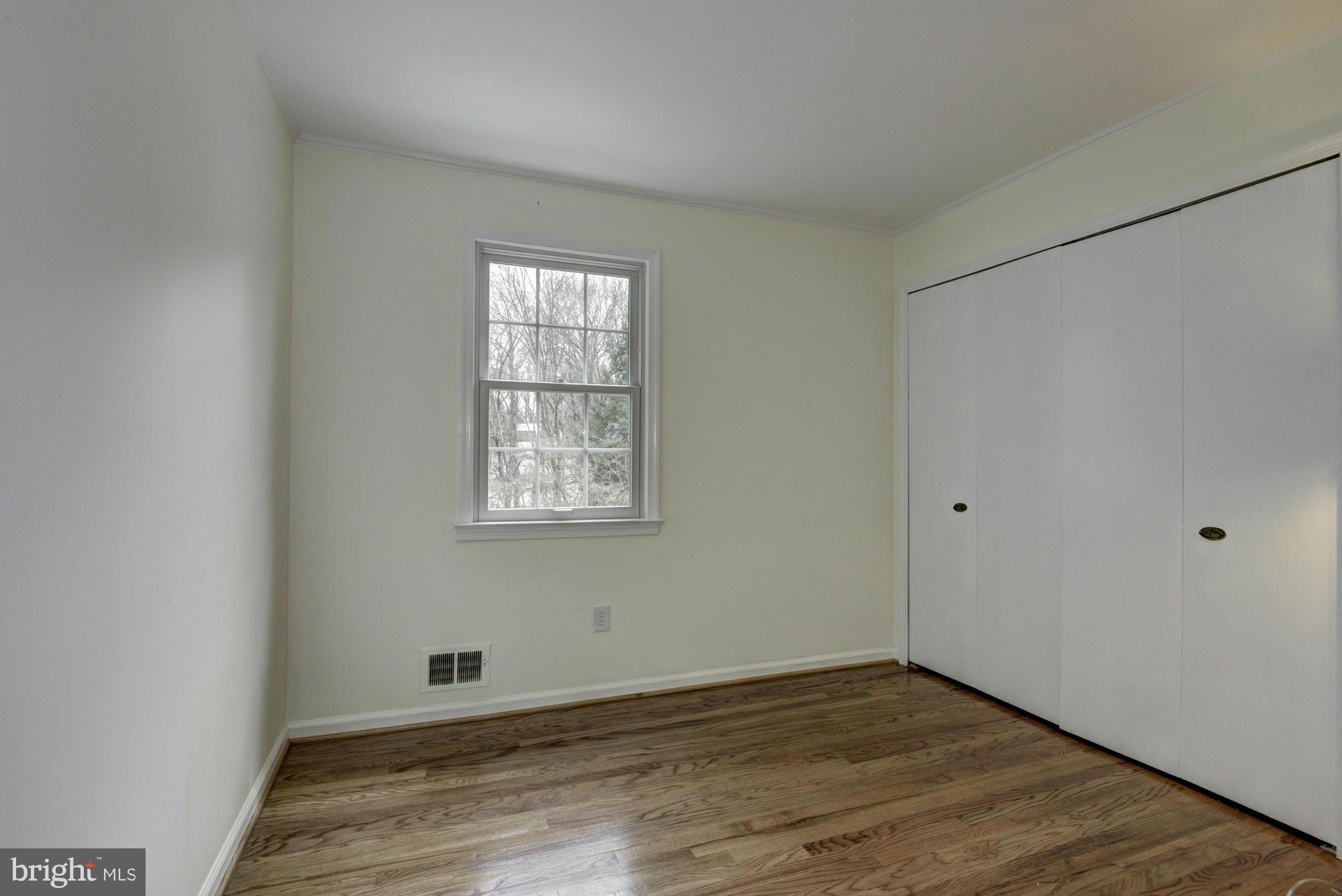 14117 Sturtevant Road Silver Spring, MD 20905 - Photo 18 of 30 a view of an empty room with wooden floor and a window