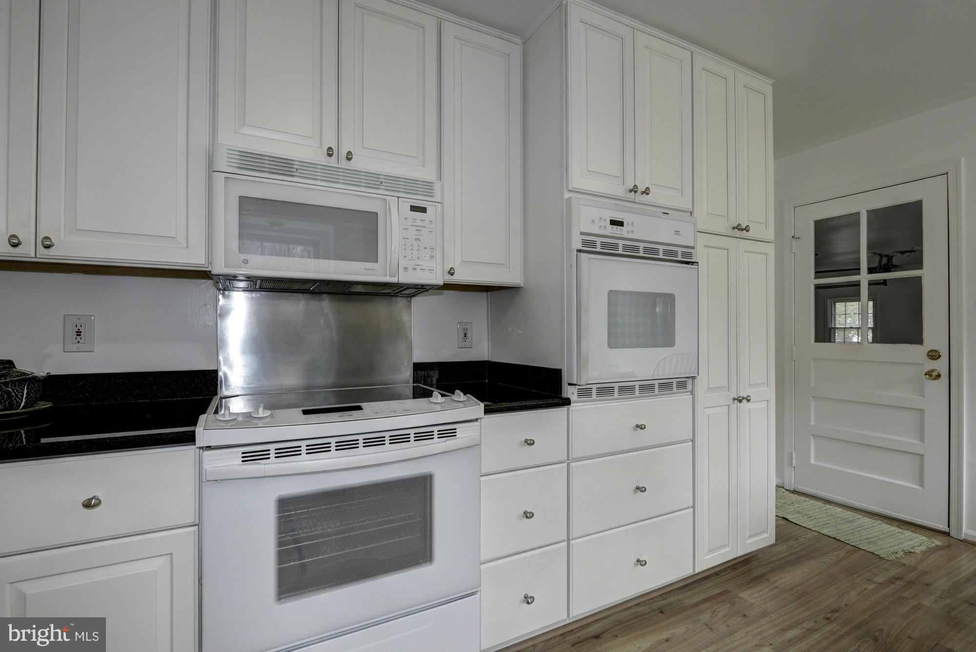 14117 Sturtevant Road Silver Spring, MD 20905 - Photo 5 of 30 a kitchen with white cabinets and appliances