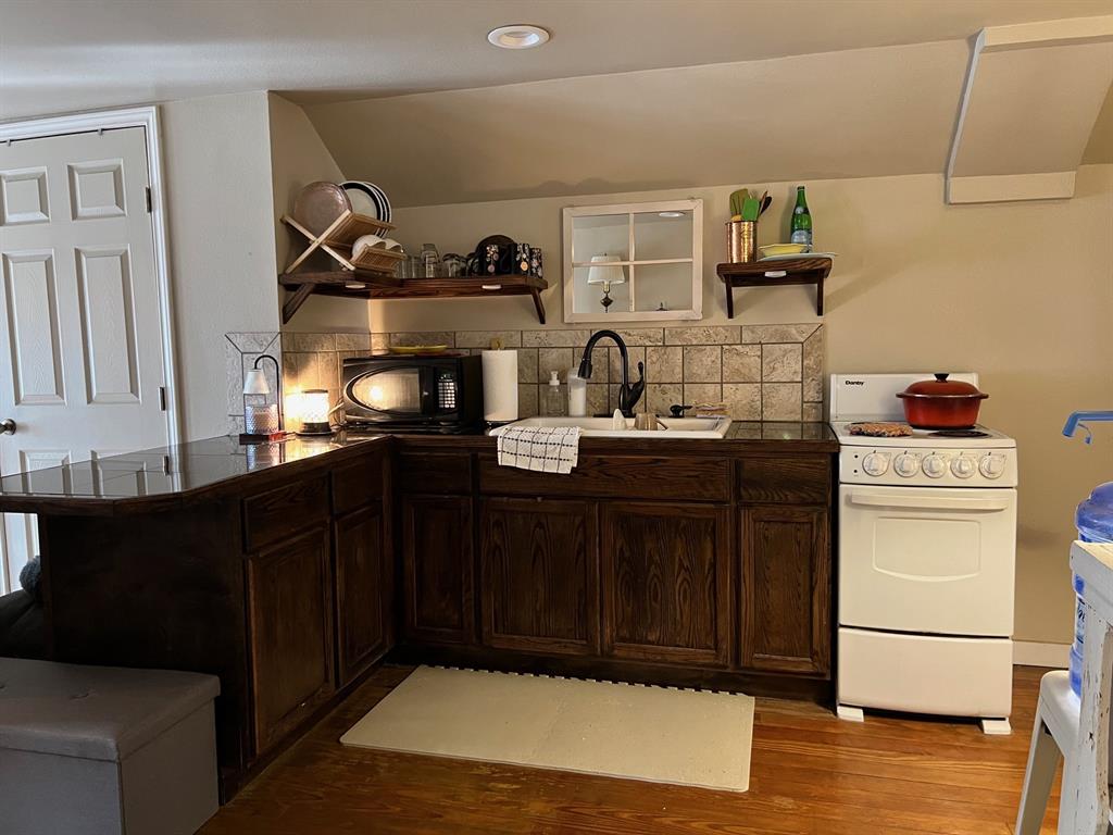 306 North Austin Street Comanche, TX 76442 - Photo 27 of 37 a kitchen with a sink and cabinets
