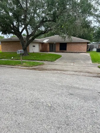 a front view of a house with a garden and trees