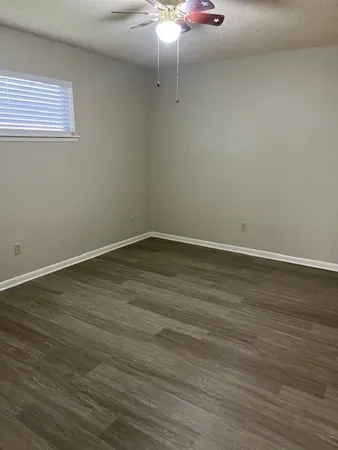 a view of a room with wooden floor and cabinets