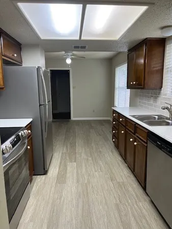 a kitchen with stainless steel appliances granite countertop a stove a sink and a refrigerator