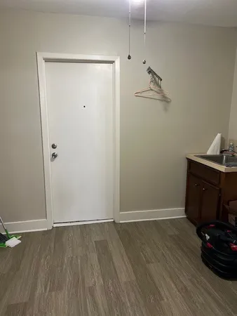 an empty room with wooden floor and cabinet