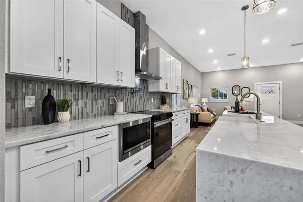 a kitchen with stainless steel appliances granite countertop a sink a stove and cabinets