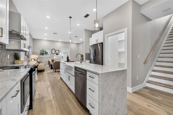 a large kitchen with stainless steel appliances lots of counter space and wooden floor
