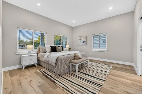a bedroom with a bed and wooden floor