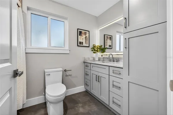 a bathroom with a granite countertop sink mirror and vanity