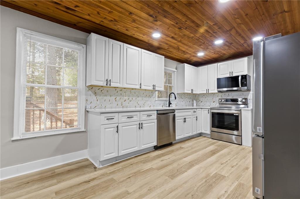 800 Post Rd Circle Stone Mountain, GA 30088 - Photo 13 of 45 a kitchen with granite countertop a refrigerator oven a sink and dishwasher with wooden floor