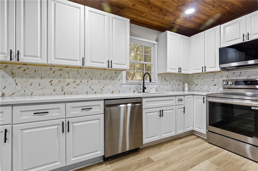 800 Post Rd Circle Stone Mountain, GA 30088 - Photo 14 of 45 a kitchen with granite countertop white cabinets white stainless steel appliances and a sink