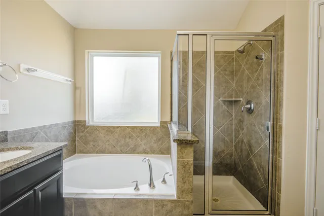 a bathroom with a granite countertop bathtub shower and sink