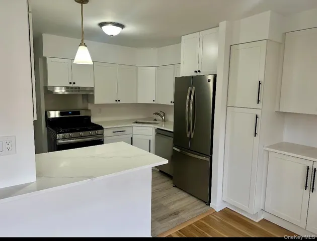 a kitchen with kitchen island a counter top space stainless steel appliances and cabinets