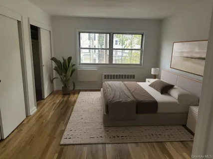 a bedroom with a large bed windows and wooden floor