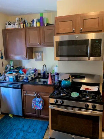 a kitchen with stainless steel appliances a stove a microwave and sink