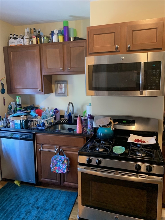 5 Blake Street, Unit 1 Cambridge, MA 02140 - Photo 19 of 41 a kitchen with stainless steel appliances granite countertop a stove and a microwave