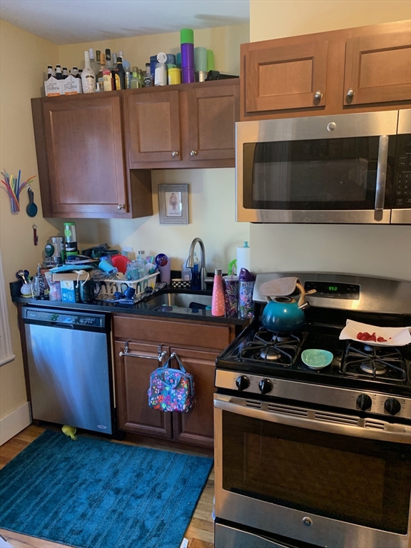 5 Blake Street, Unit 1 Cambridge, MA 02140 - Photo 20 of 41 a kitchen with stainless steel appliances a stove a microwave and sink