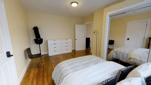 a bedroom with a bed and a flat tv screen on dresser