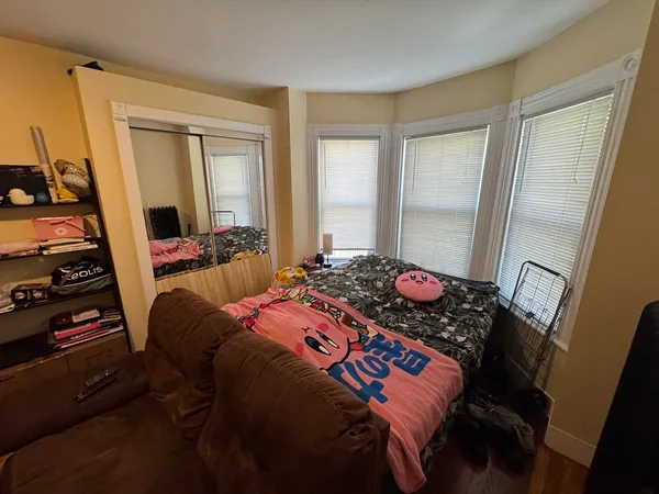 a bedroom with a bed and wooden floor