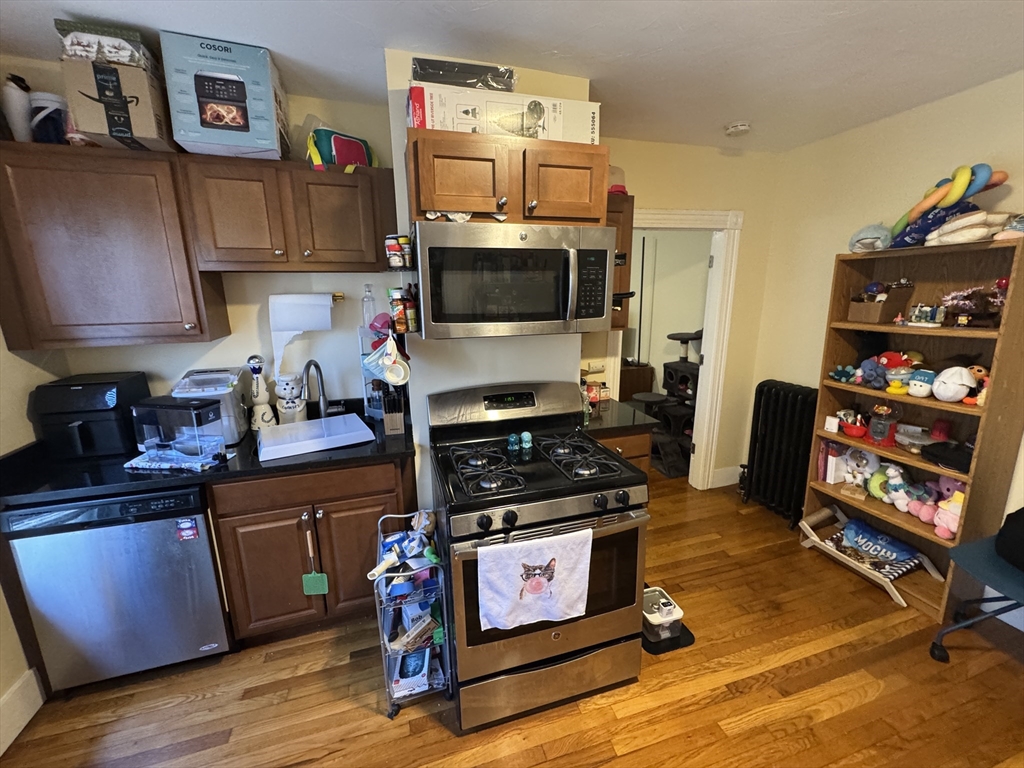 5 Blake Street, Unit 1 Cambridge, MA 02140 - Photo 37 of 41 a kitchen with granite countertop a stove and cabinets