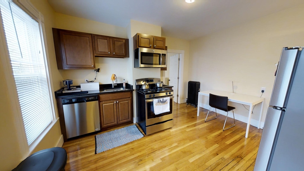5 Blake Street, Unit 1 Cambridge, MA 02140 - Photo 5 of 41 a kitchen with stainless steel appliances granite countertop a stove a sink and a refrigerator