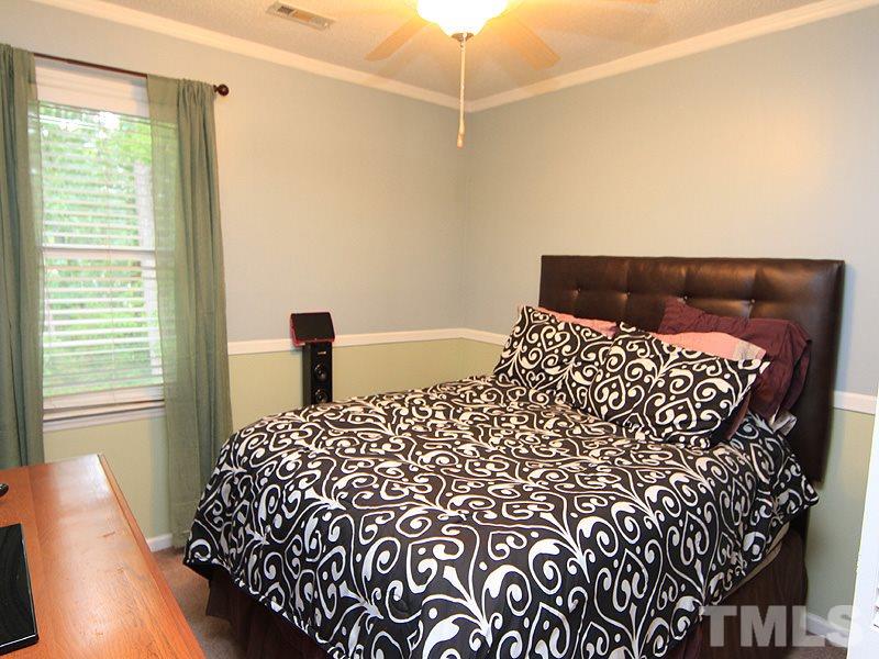 5584 Hamstead Crossing Raleigh, NC 27612 - Photo 13 of 17 a bed sitting in a bedroom next to a window