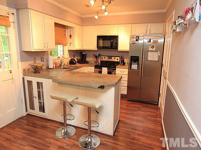 5584 Hamstead Crossing Raleigh, NC 27612 - Photo 6 of 17 a kitchen with stainless steel appliances a stove refrigerator sink and microwave
