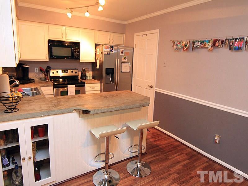 5584 Hamstead Crossing Raleigh, NC 27612 - Photo 7 of 17 a kitchen with stainless steel appliances a refrigerator and a stove top oven