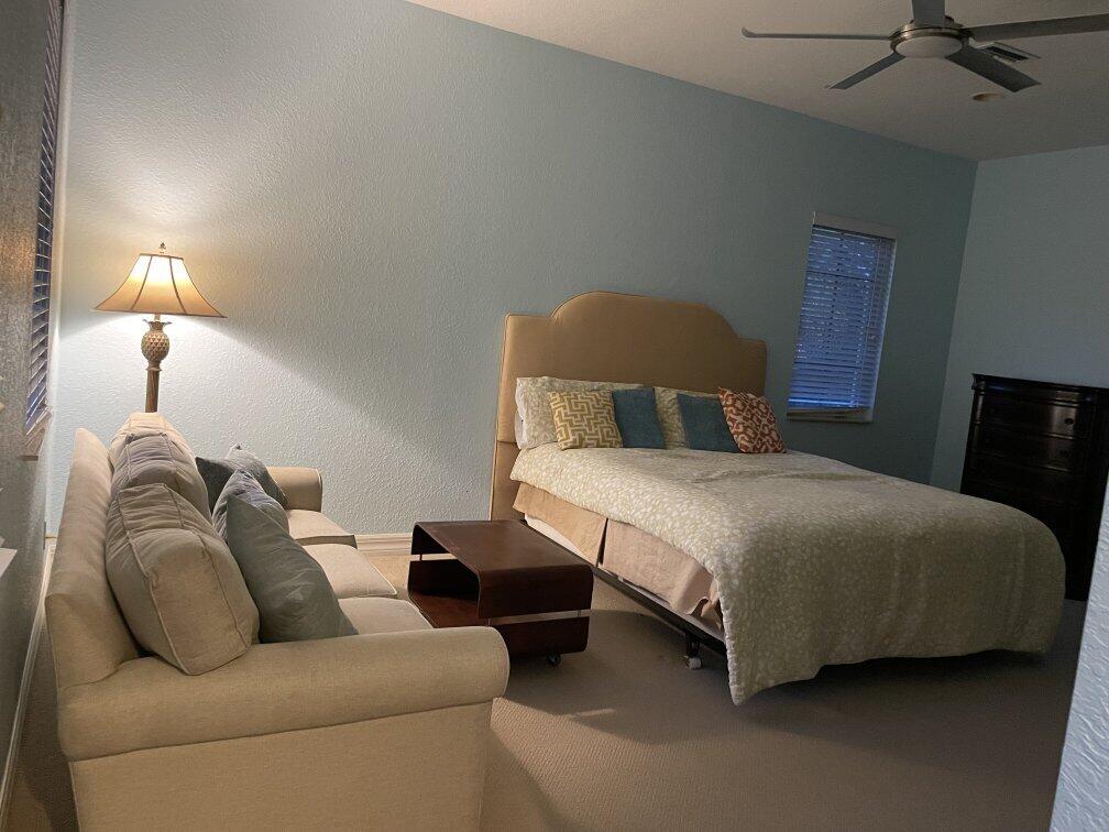 a bedroom with a bed couch and lamp
