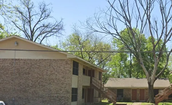 a front view of a house with a tree