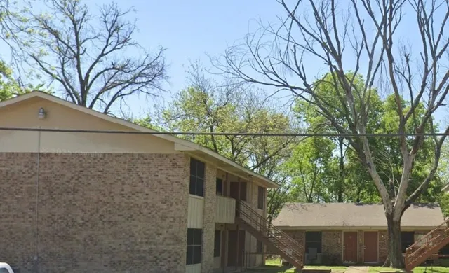 a front view of a house with a tree