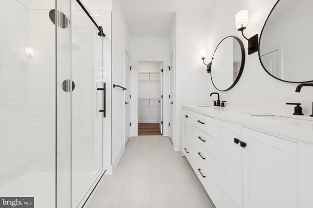 a bathroom with a double vanity sink mirror and a shower