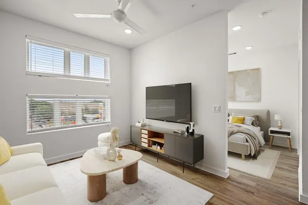 a living room with furniture a flat screen tv and large window
